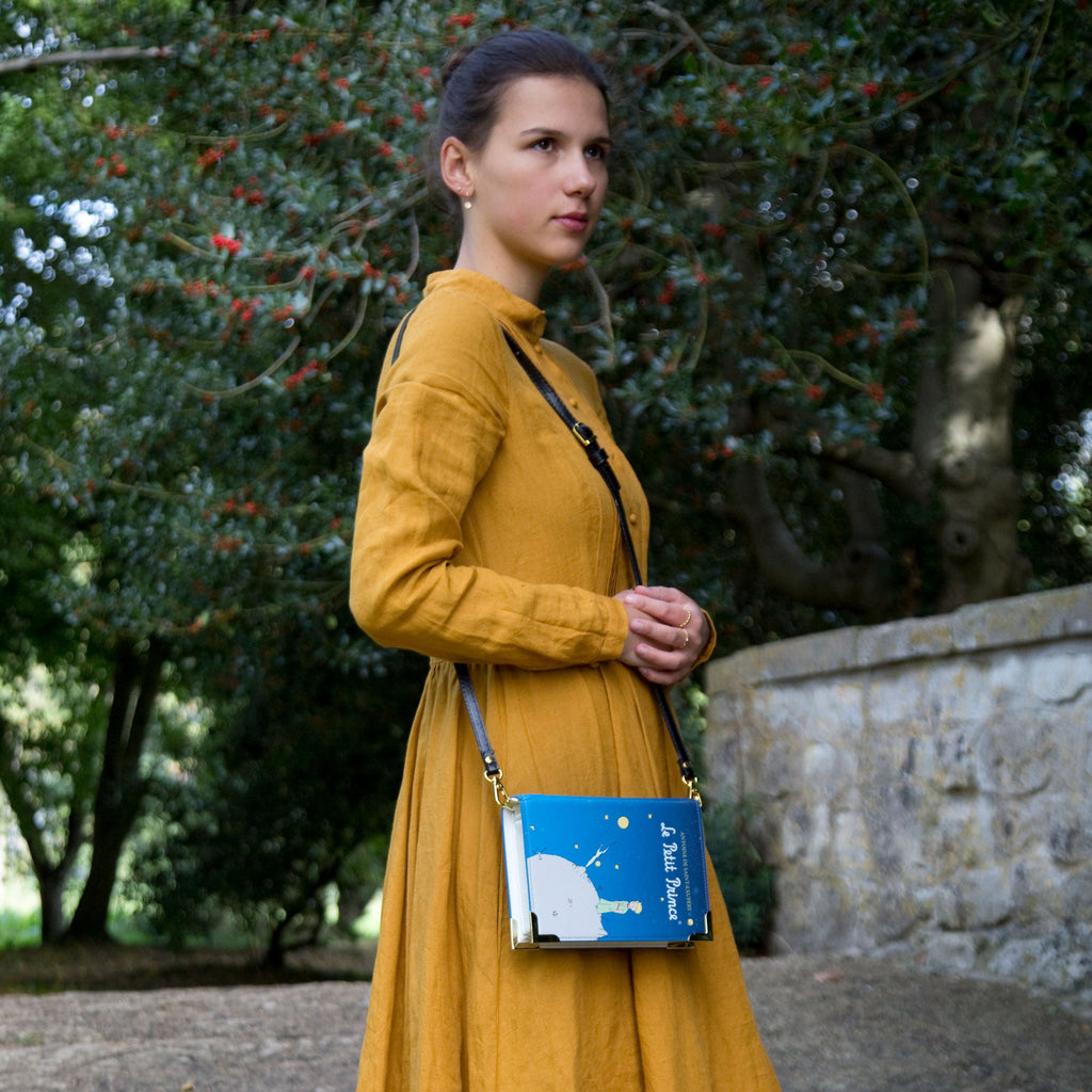 The Little Prince Blue Handbag by Antoine de Saint-Exupéry featuring Little Prince on his Home Planet design, by Well Read Co. - Model Standing